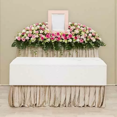 ベージュの背景に白と赤色が基調とした花がメインの祭壇