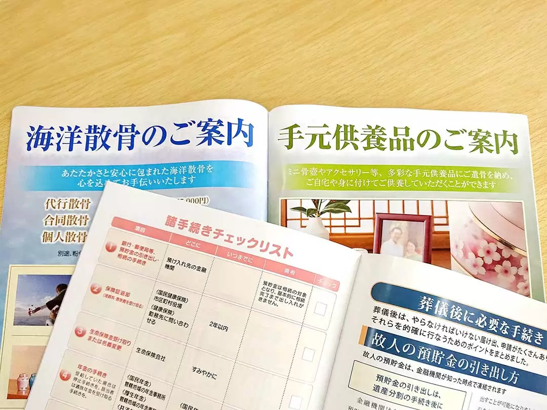 海洋散骨や手元供養品のご案内の表記がある冊子が机の上に開かれている